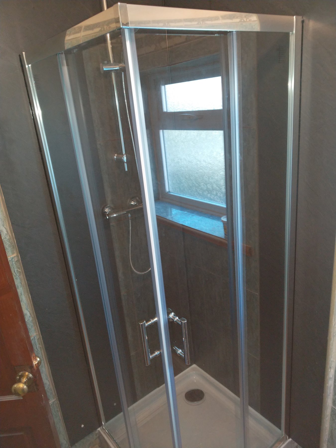 The same shower enclosure from the side, with the door closed